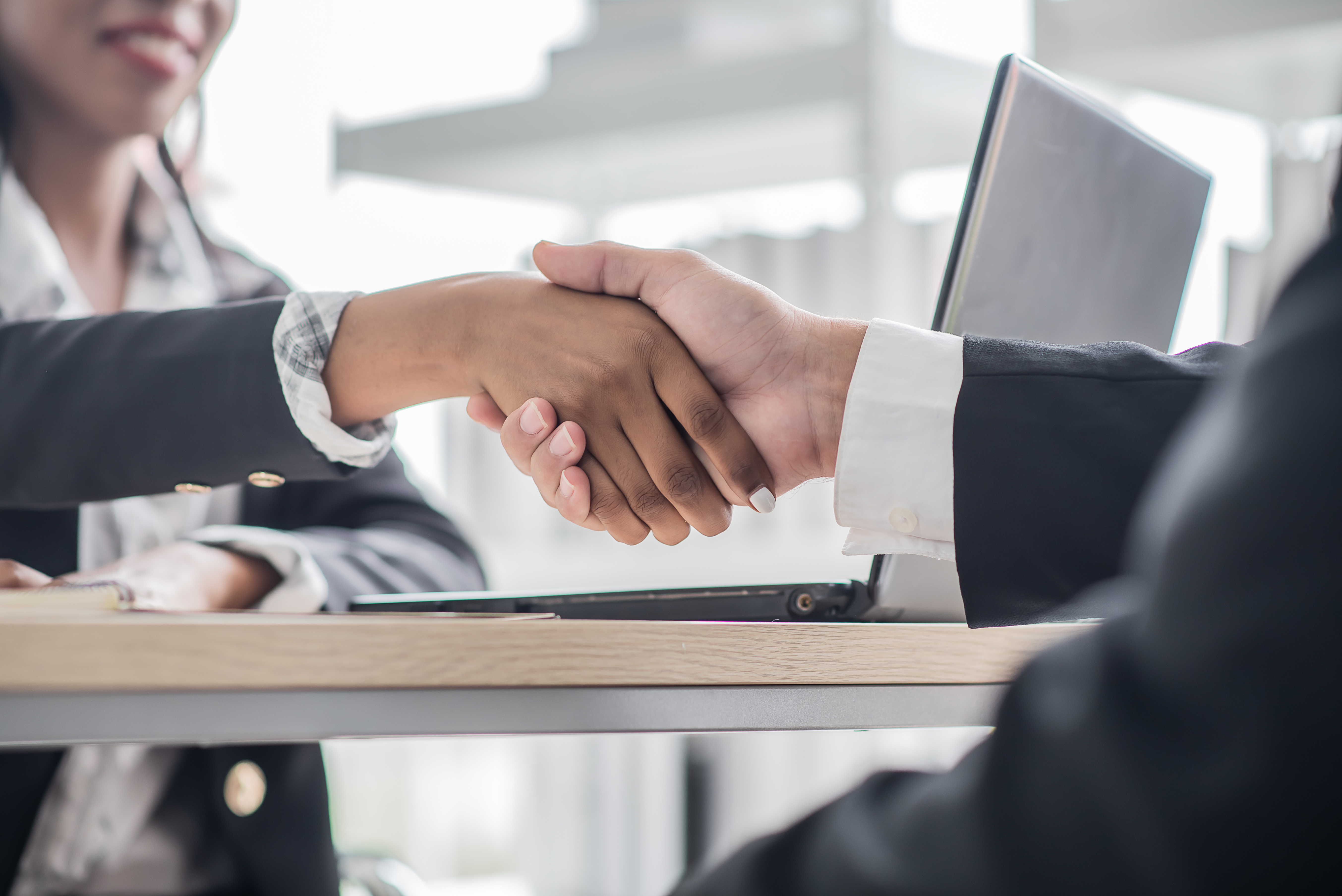 African business women shake hands with business man agreeing on
